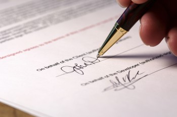 Photo of a contract being signed